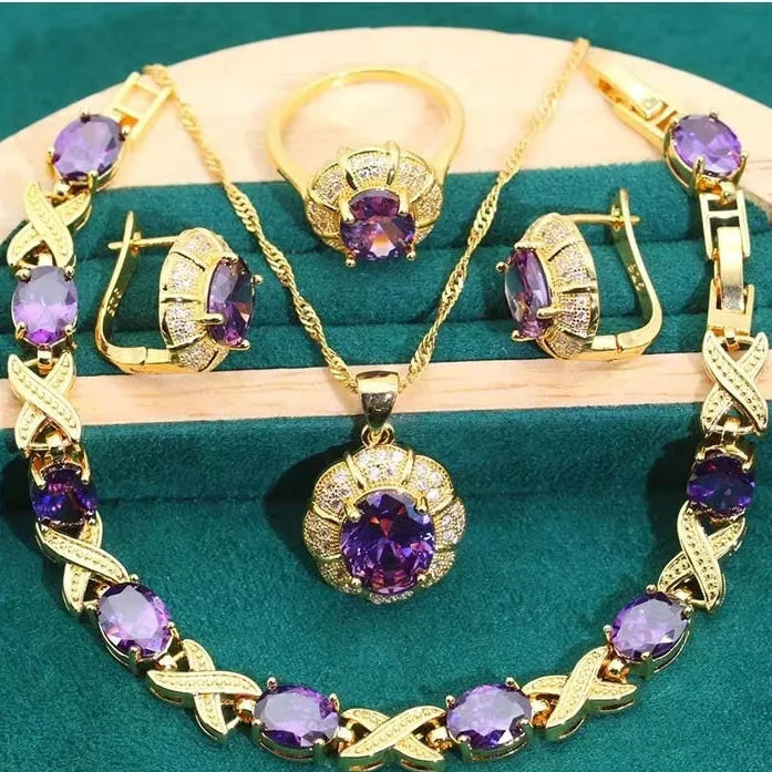 18k gold plated zircon jewellery set with necklace, earrings, ring, and bracelet on blue background