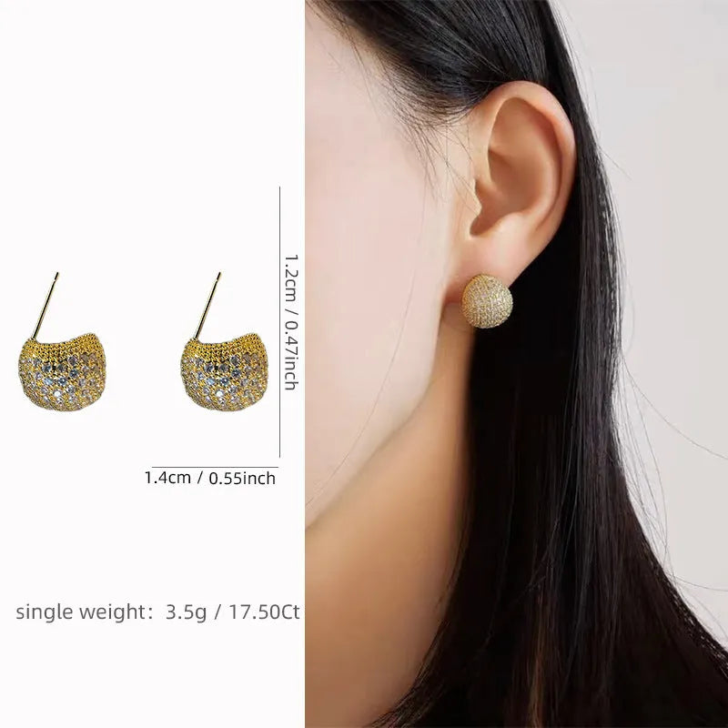 Geometric drop-shaped ear clips with spherical elements in gold and white colour options