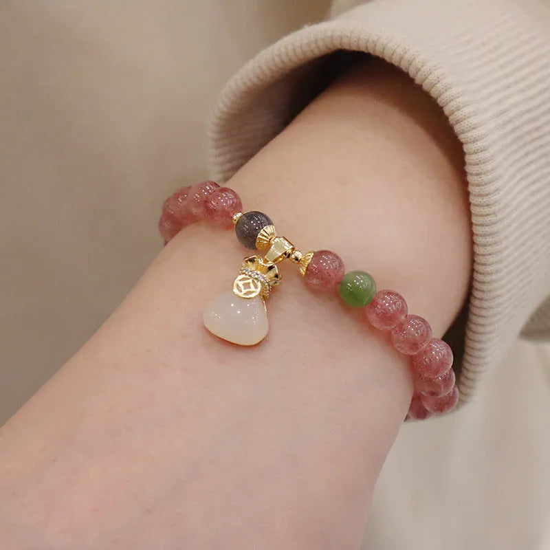 Geometric strawberry quartz women's bracelet with a lucky bag charm and silver safety buckle on a white background.