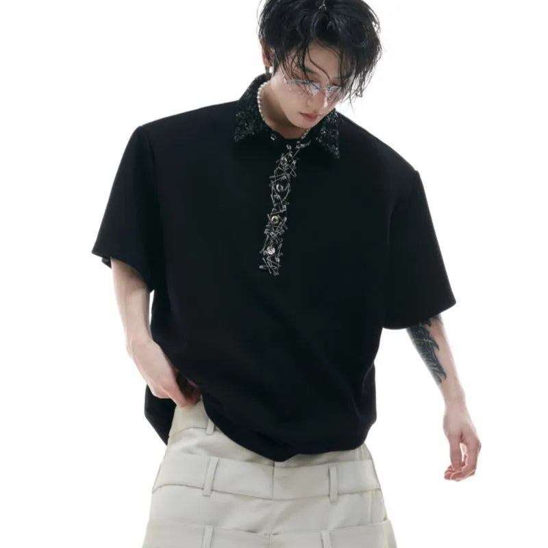 Loose-fit black men's polo t-shirt with a square collar and heavy sequin embroidery on the chest.