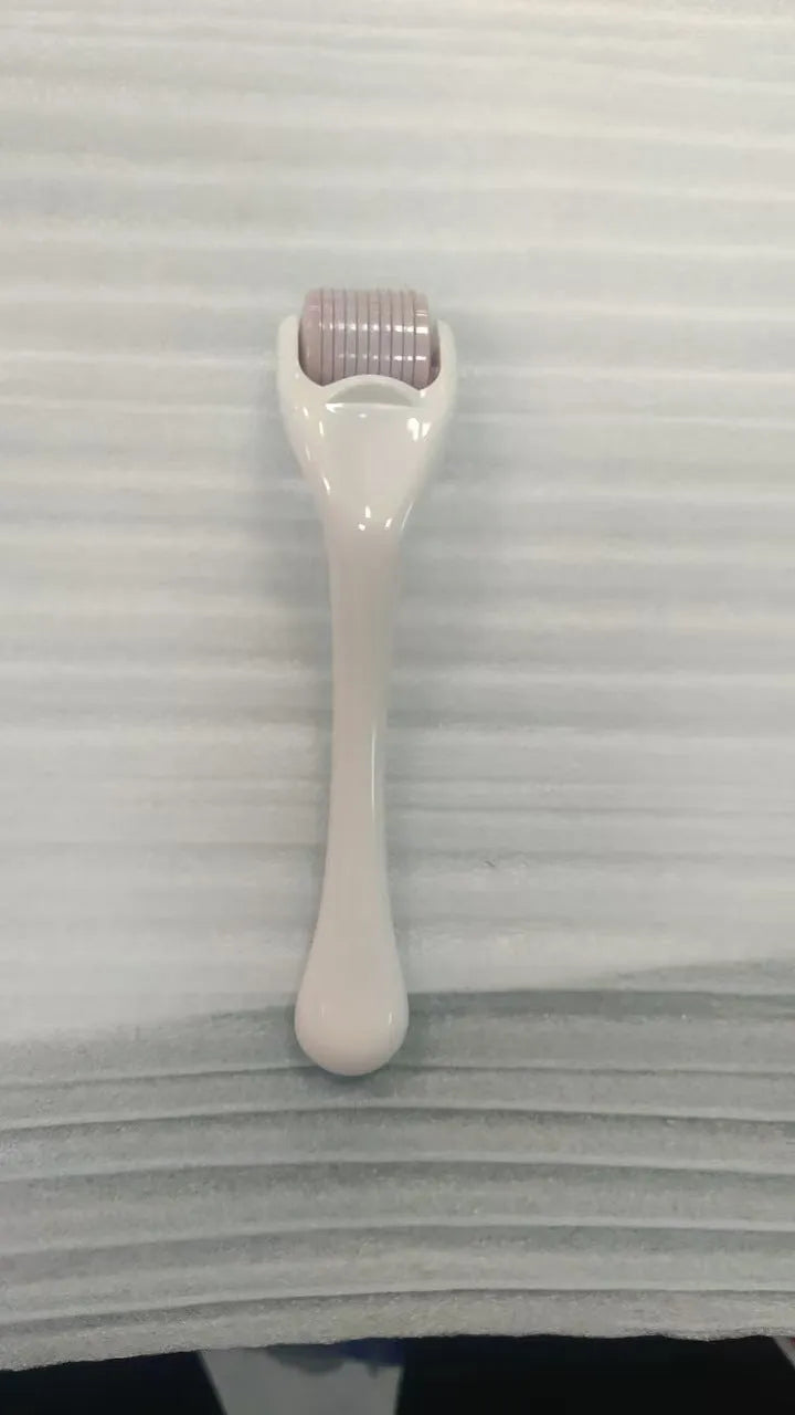 540 micro needle roller tool with black handle and coloured wheel on a white background.