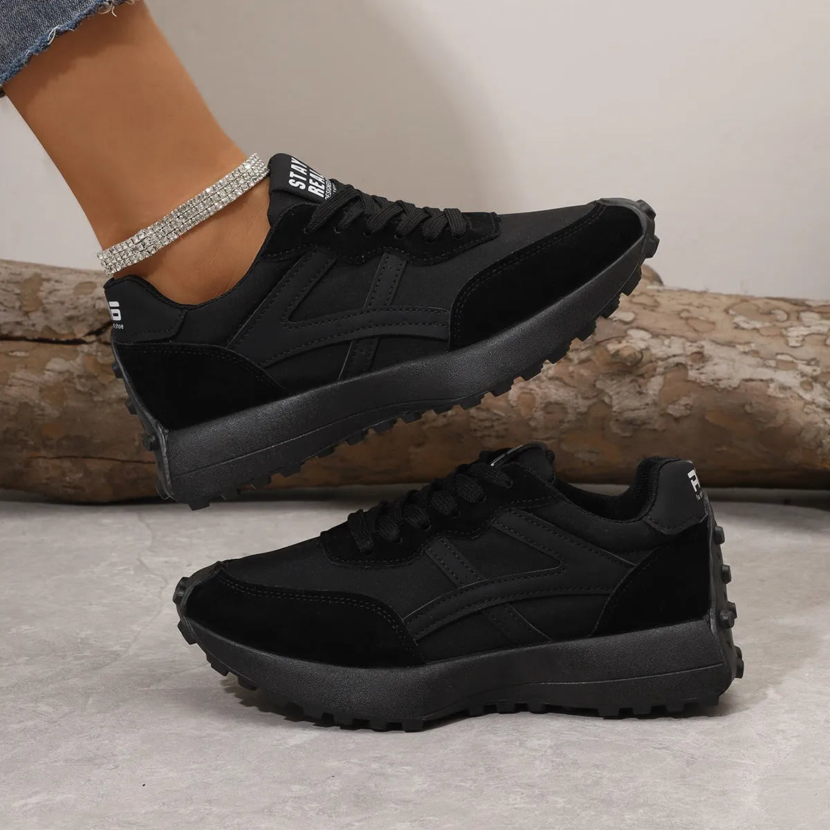 Black mesh sports flat shoes for women with synthetic leather upper and rubber sole, side view