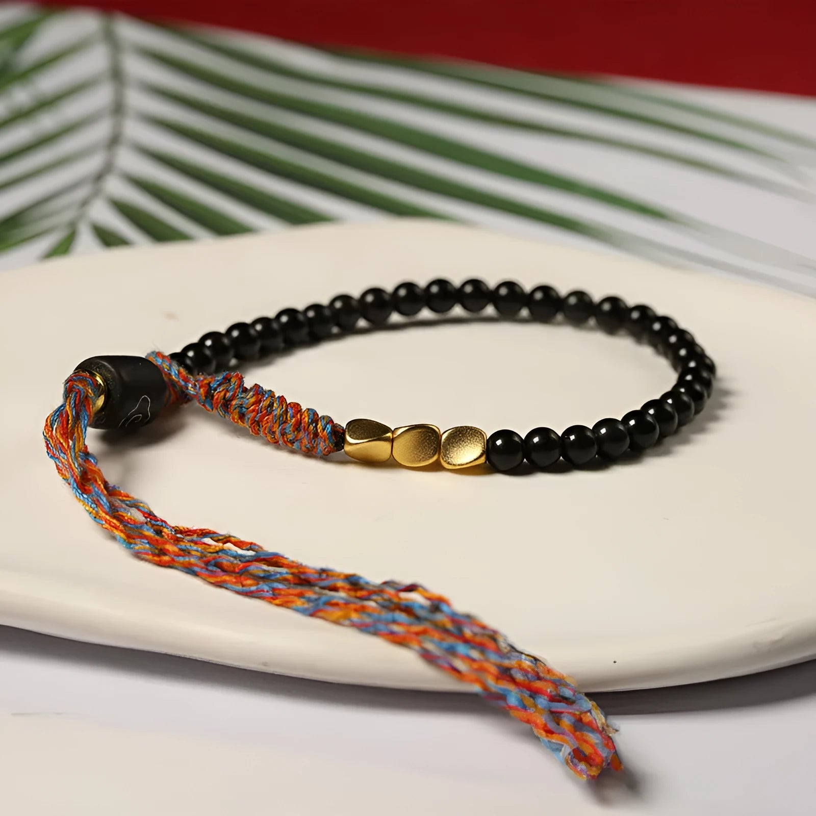 Hand-woven obsidian carrying strap bracelet showing textured surface and adjustable 15.5-16cm length