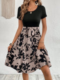 Khaki women's A-line dress with floral print, lace-up neckline, and a shoulder strap detail.