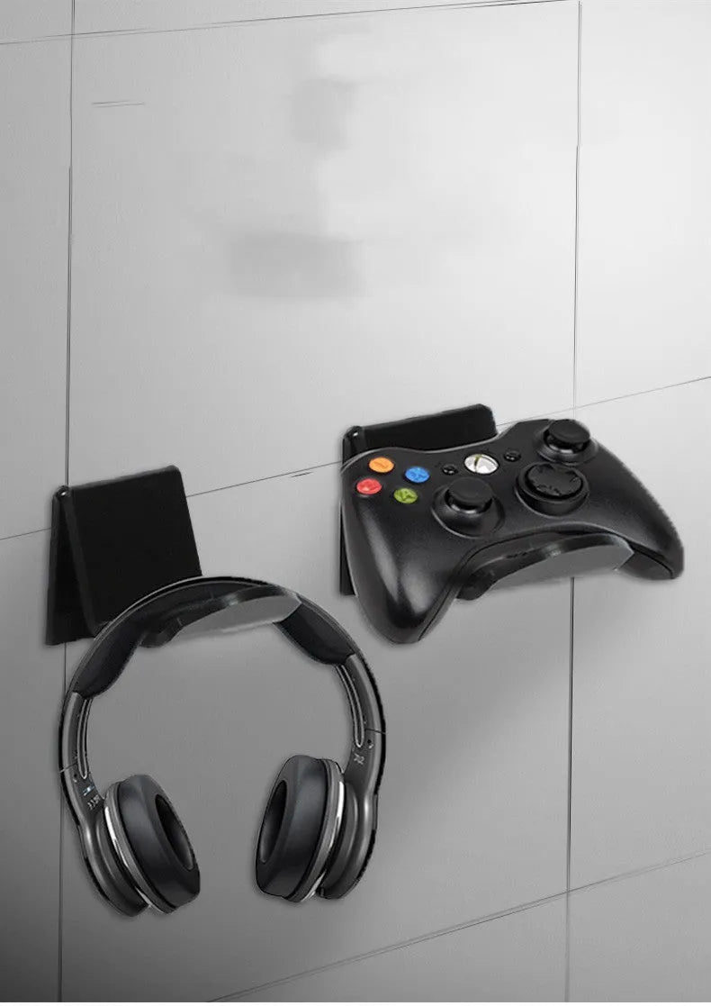 Universal black game controller wall bracket mounted on a wall holding a PlayStation controller.