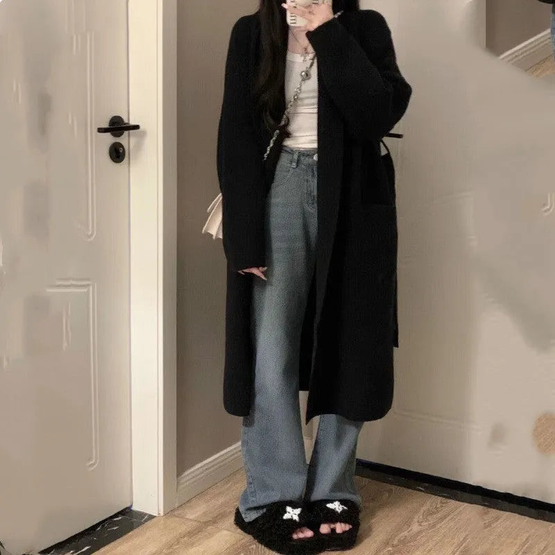 A loose, thick grey knitted women's cardigan with a 3D pattern, shown open as a cardigan.