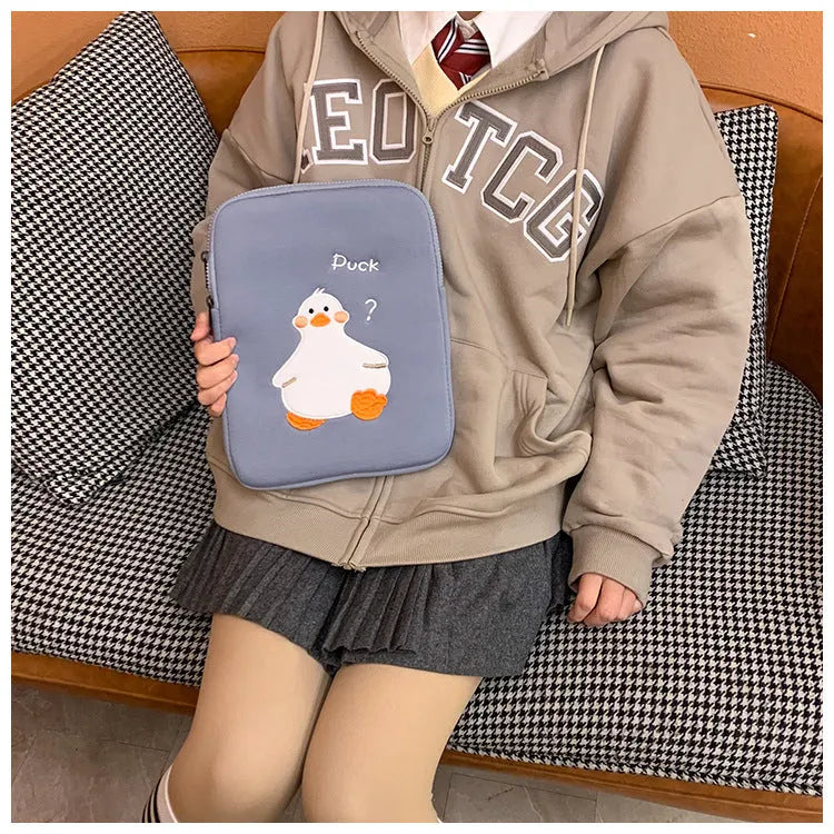 Blue cotton tablet case with embroidered cartoon duck design and a black zipper, shown open.