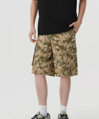 Man wearing loose, cropped camouflage shorts in a khaki colourway, showcasing the summer workwear style.
