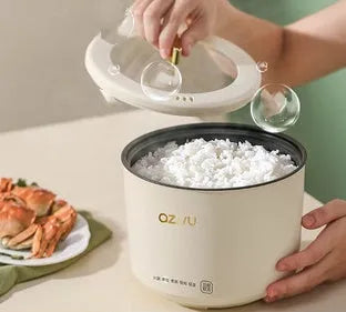 Small round blue and black miniature automatic rice cooker with steam pan on a kitchen counter.