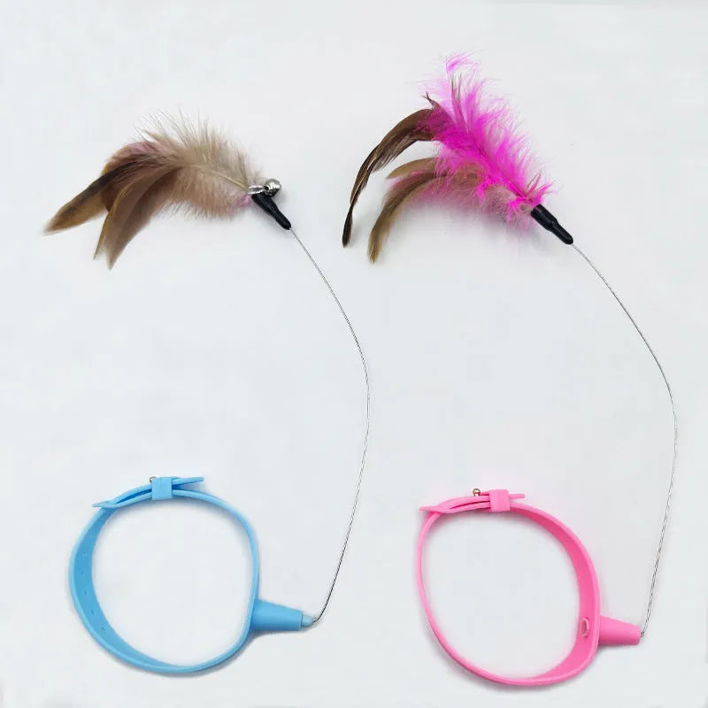 Pink and blue adjustable collar cat teaser toy with feather and bell attachment on a white background