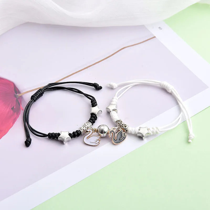 Magnet suction couple bracelets with alloy construction and various pendant designs including crowns and hearts