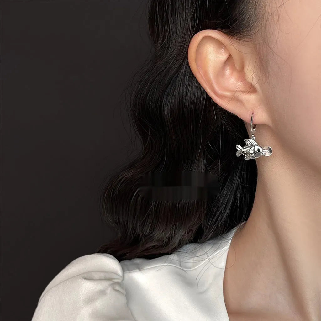 Copper electroplated bubble fish design earrings with goldfish animal modelling on a white background.
