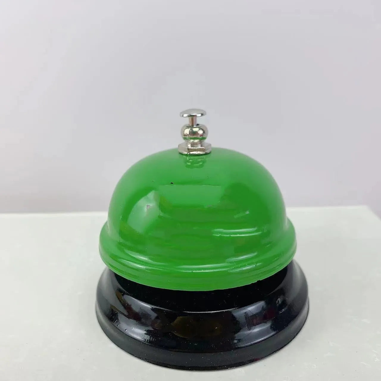 Iron game bell in assorted colours including red, blue, green, pink, and yellow for service or classroom use.