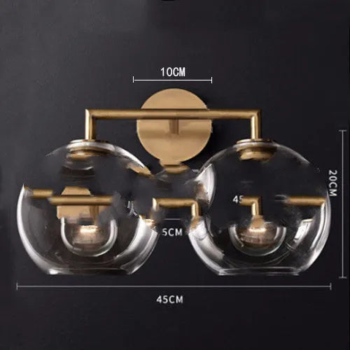Gold bronze or black wall lamp with triangular transparent glass shade and wrought iron frame for bedside or hallway use