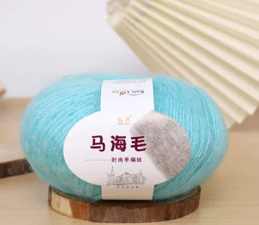 Ball of mohair yarn for DIY scarf knitting in one of 34 colours, including white, pink, blue, and green.