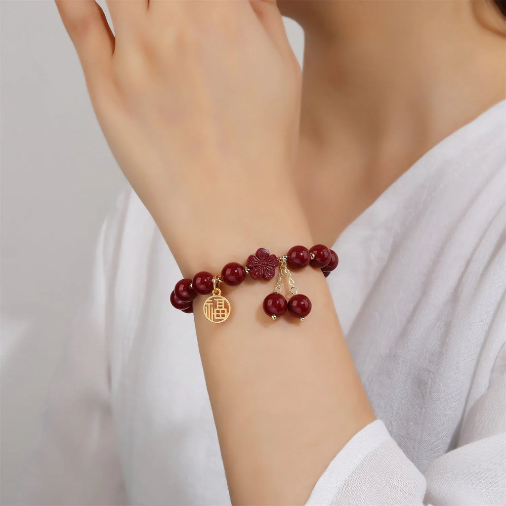 Women's cinnabar bracelet with Fu character charm and peach blossom tassels in purple gold sand colour
