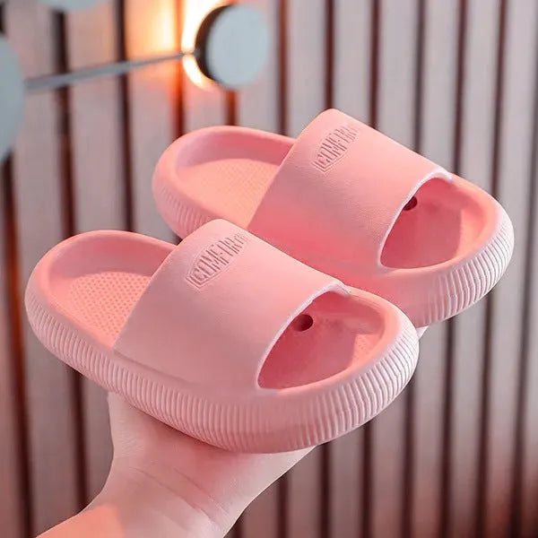 Colourful children's EVA slippers with textured sole, shown in blue, green, orange, pink, and yellow.