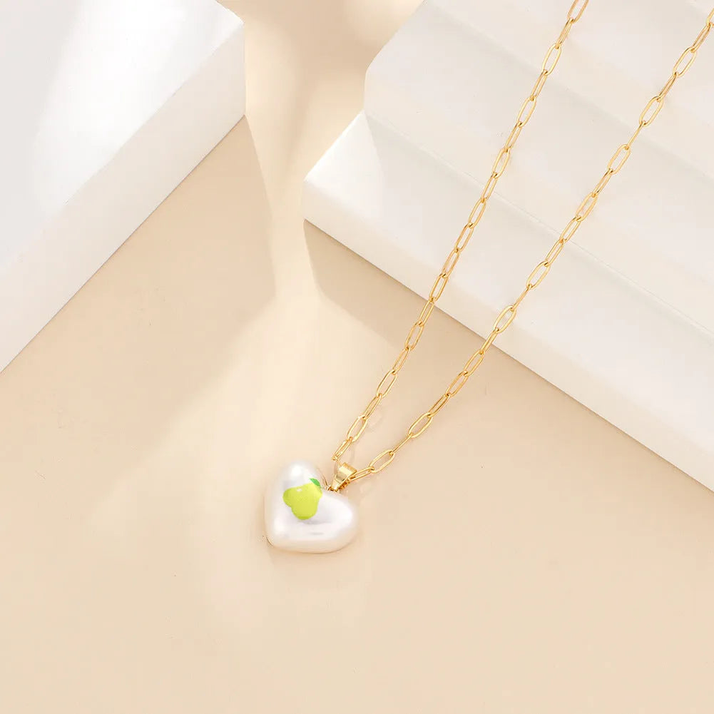 Heart-shaped necklace with fruit pendant on geometric chain showing strawberry pineapple apple pear cherry options