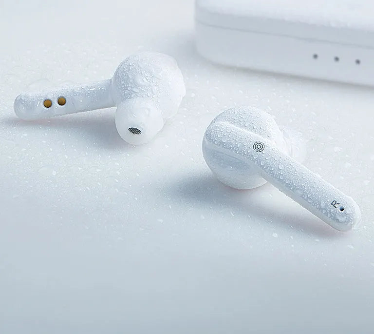 Black and white true wireless stereo earbuds with a charging case on a table