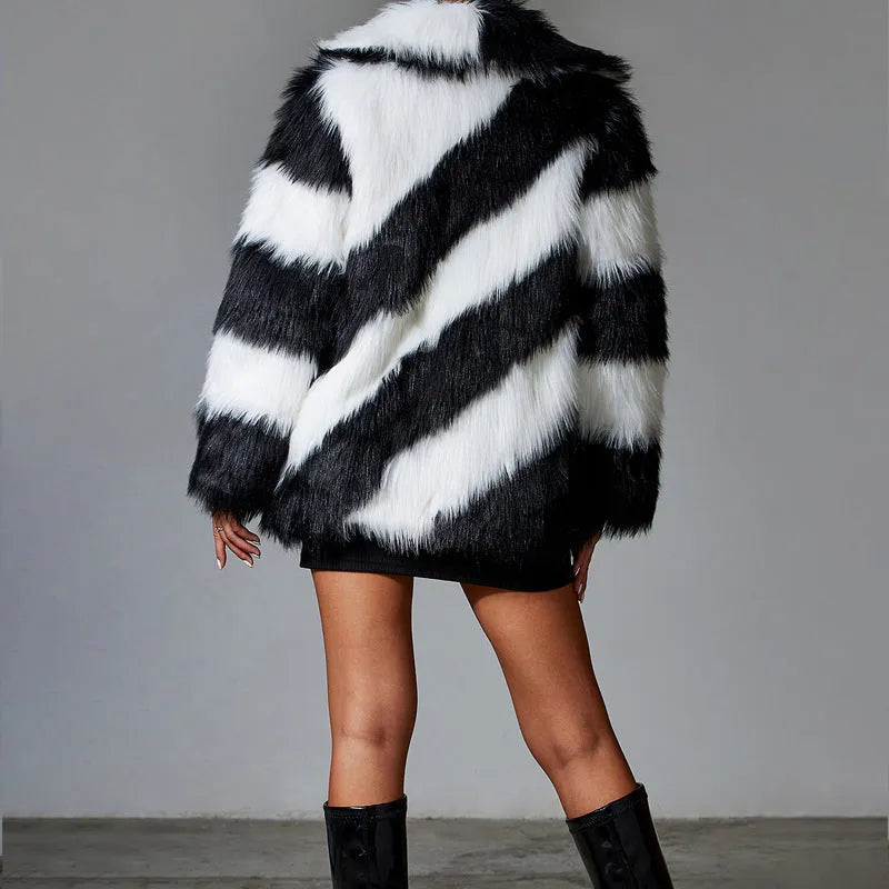 Women's mid-length coat in contrasting colours with a faux fur collar.