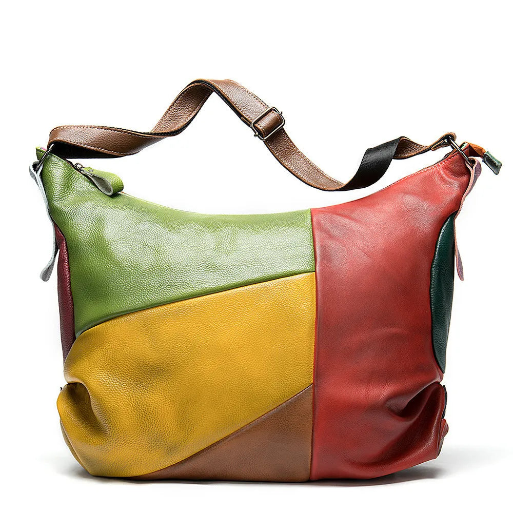 Brown cowhide leather crossbody travel bag with stitching detail, shown with laptop and A4 magazine.
