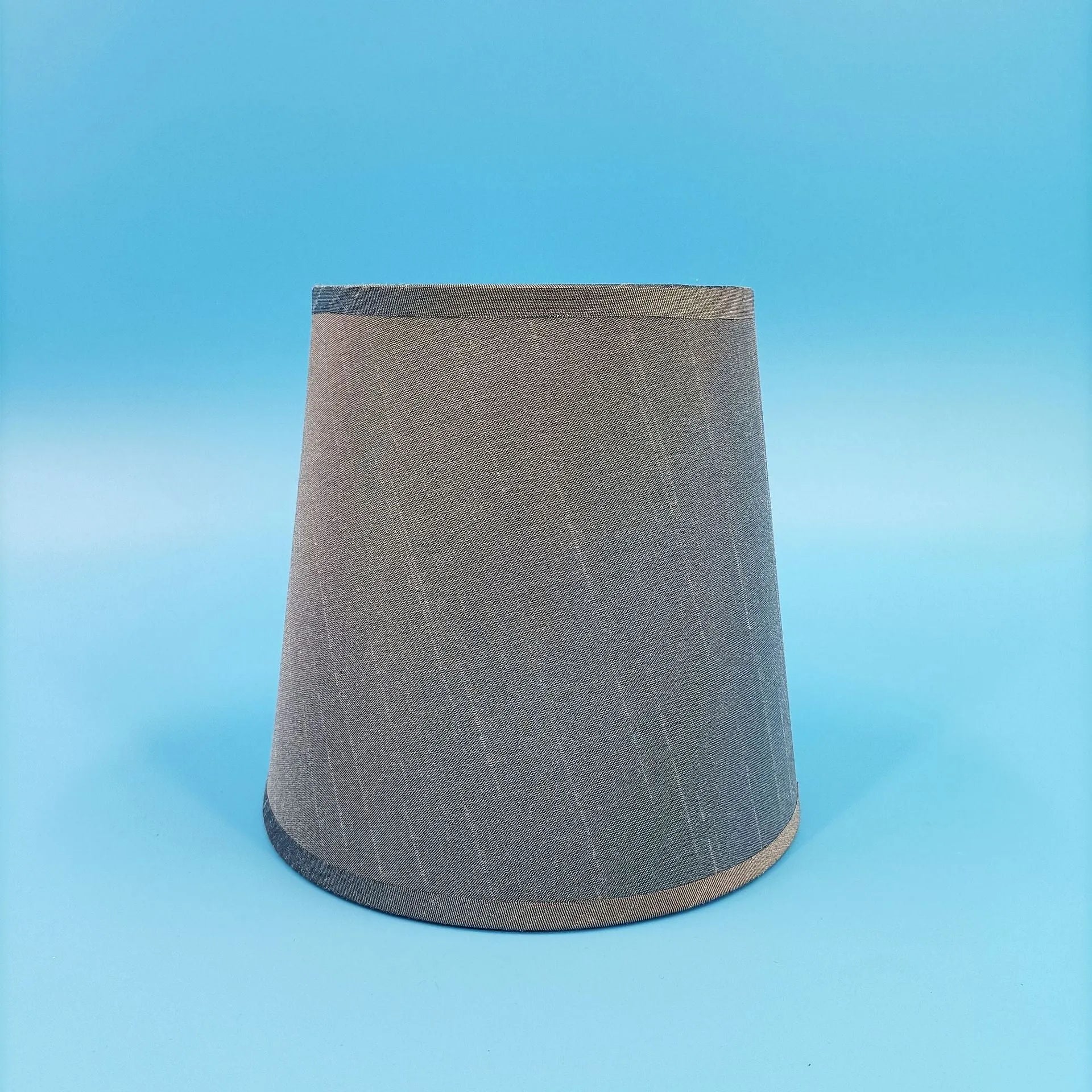 Modern minimalist fabric lampshade in a grey colour on a table lamp base.