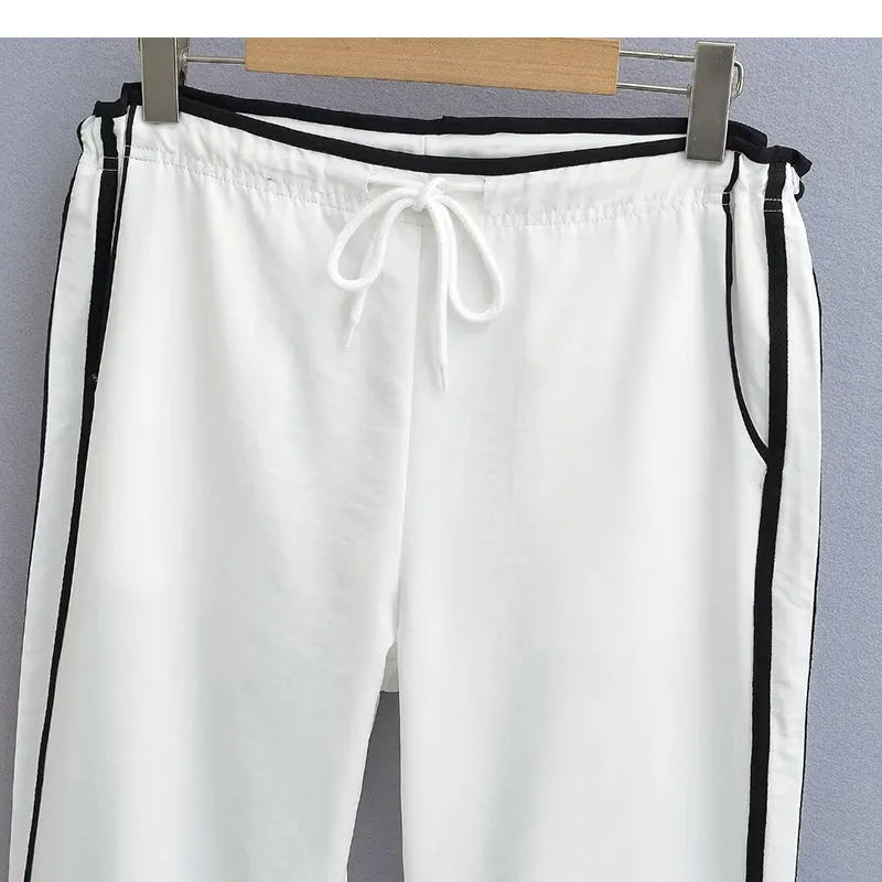 Women's navy blue straight-leg trousers with a white contrast ribbon detail sewn along the side seams.