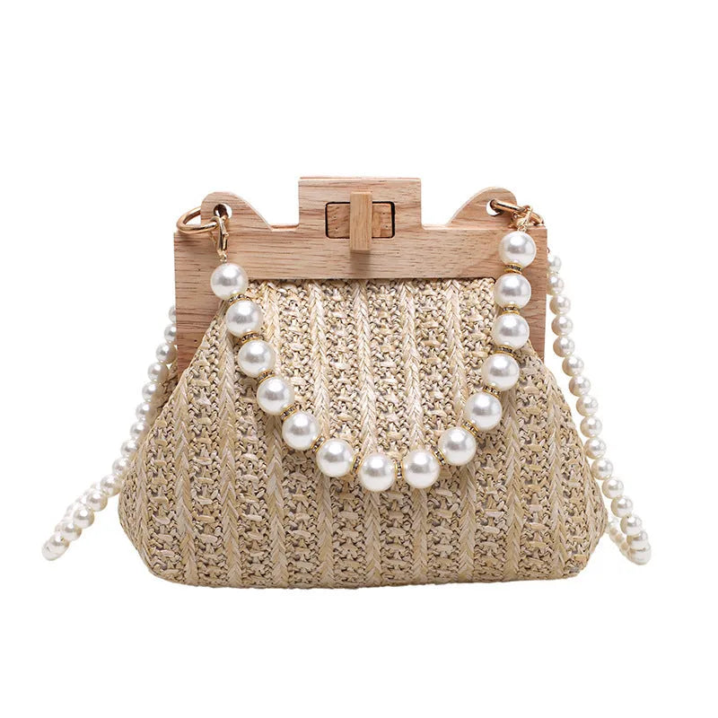 Women's woven straw shoulder bag with pearl chain detail showing horizontal square shape and multiple internal pockets