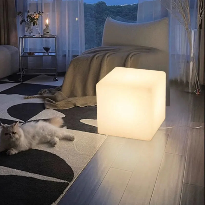 Modern square LED cube light stool in a garden setting, showcasing its clean design and luminous top.