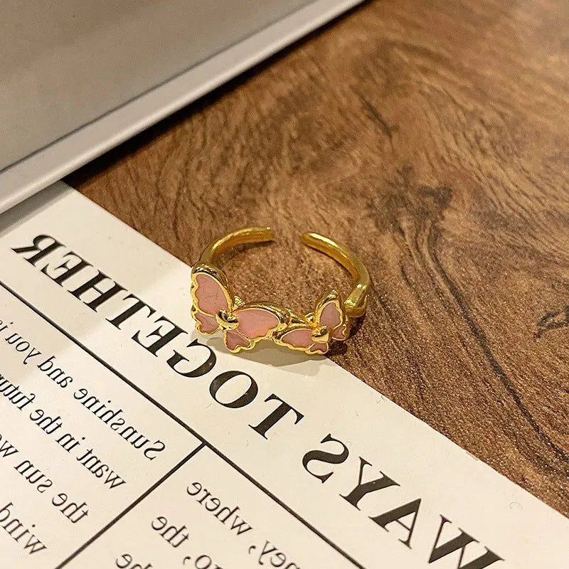Creative butterfly design women's ring in copper with oil drip finish, showing an open loop style.