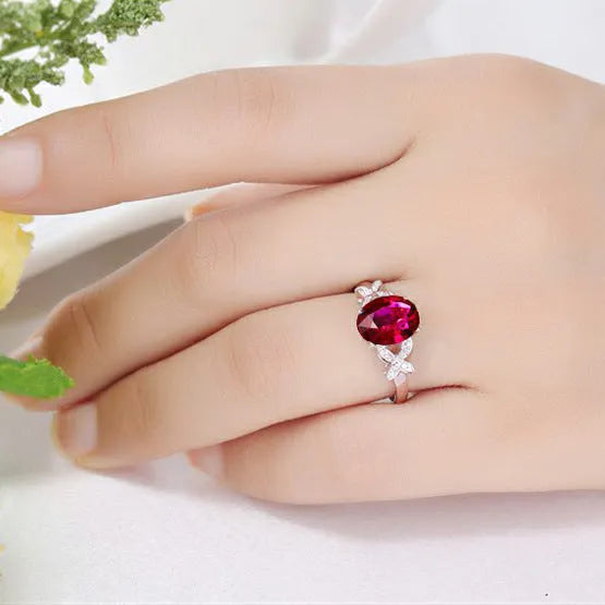 Women's butterfly-shaped ring with heart crystal in rose gold plating on blue or red background