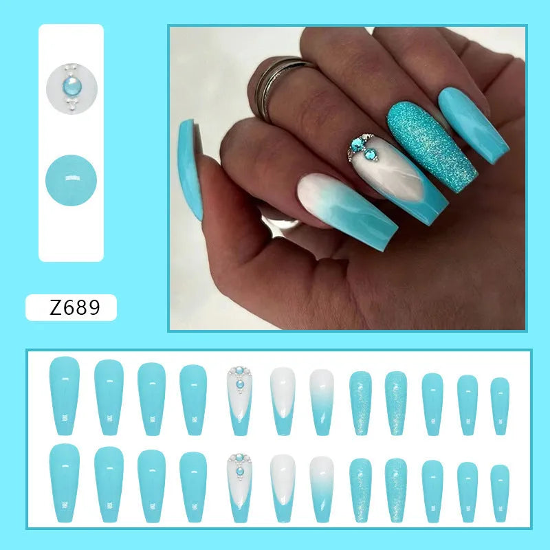 Long ballet shaped false nails in solid blue diamond colour with glitter adhesive glue.