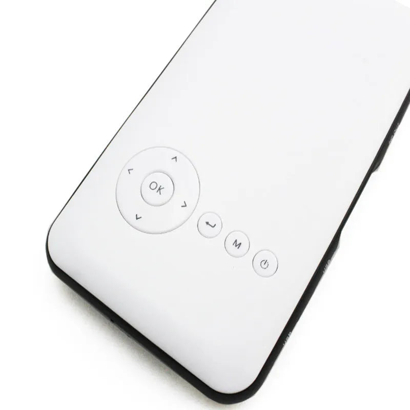 White smart handheld projector with Android system, DLP technology, wireless projection capability, placed on a table