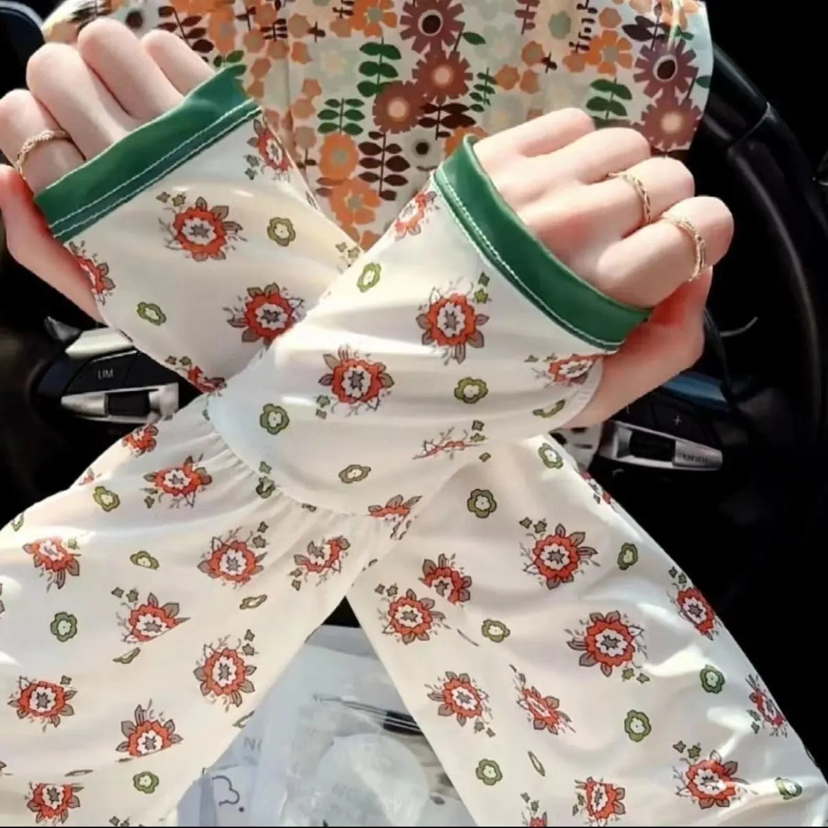 A pair of lightweight ice silk sun protection sleeve gloves in a floral print pattern, covering from wrist to elbow.