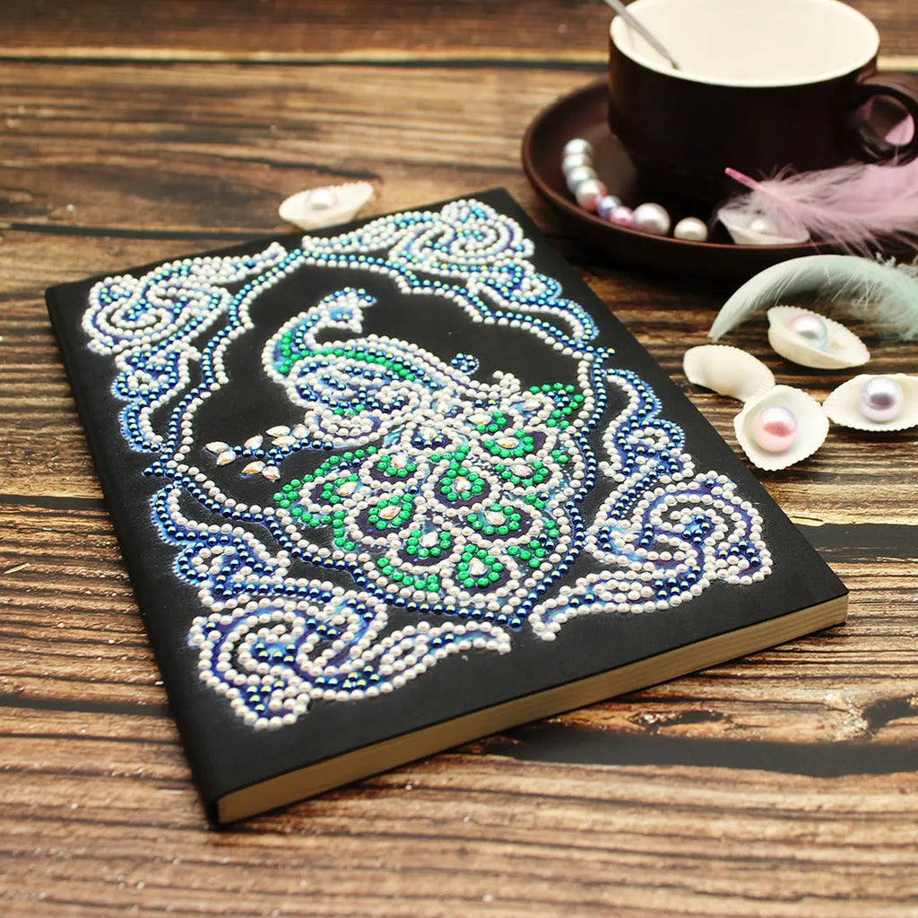 Black A5 Peacock Beauty diamond painting notebook with sparkling shaped drills on cover, showing 142x207mm size.
