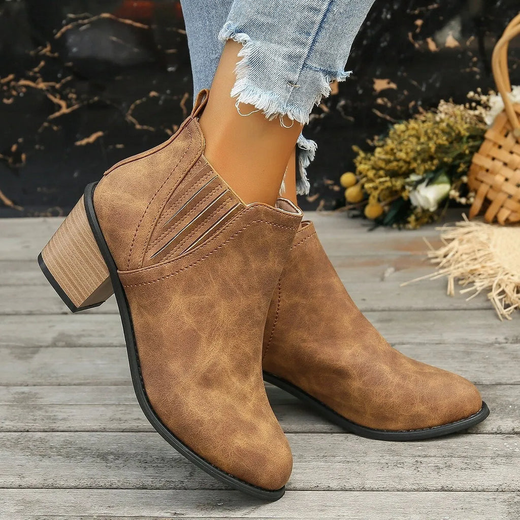 Black women's slip-on ankle boots with a pointed toe and thick square heel on a rubber sole.