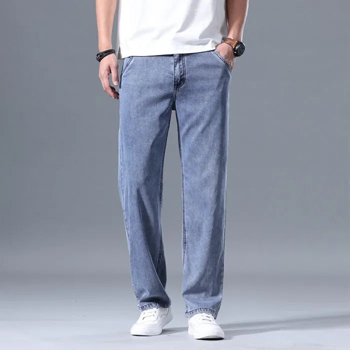 Man wearing light blue loose-fit straight-leg lyocell jeans with a zip fly