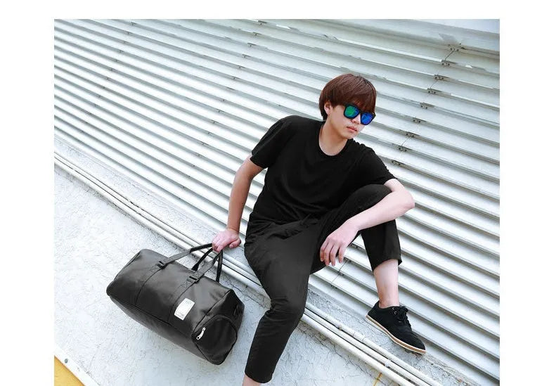 Black waterproof sports duffle bag with a separate side shoe compartment and diagonal shoulder straps.