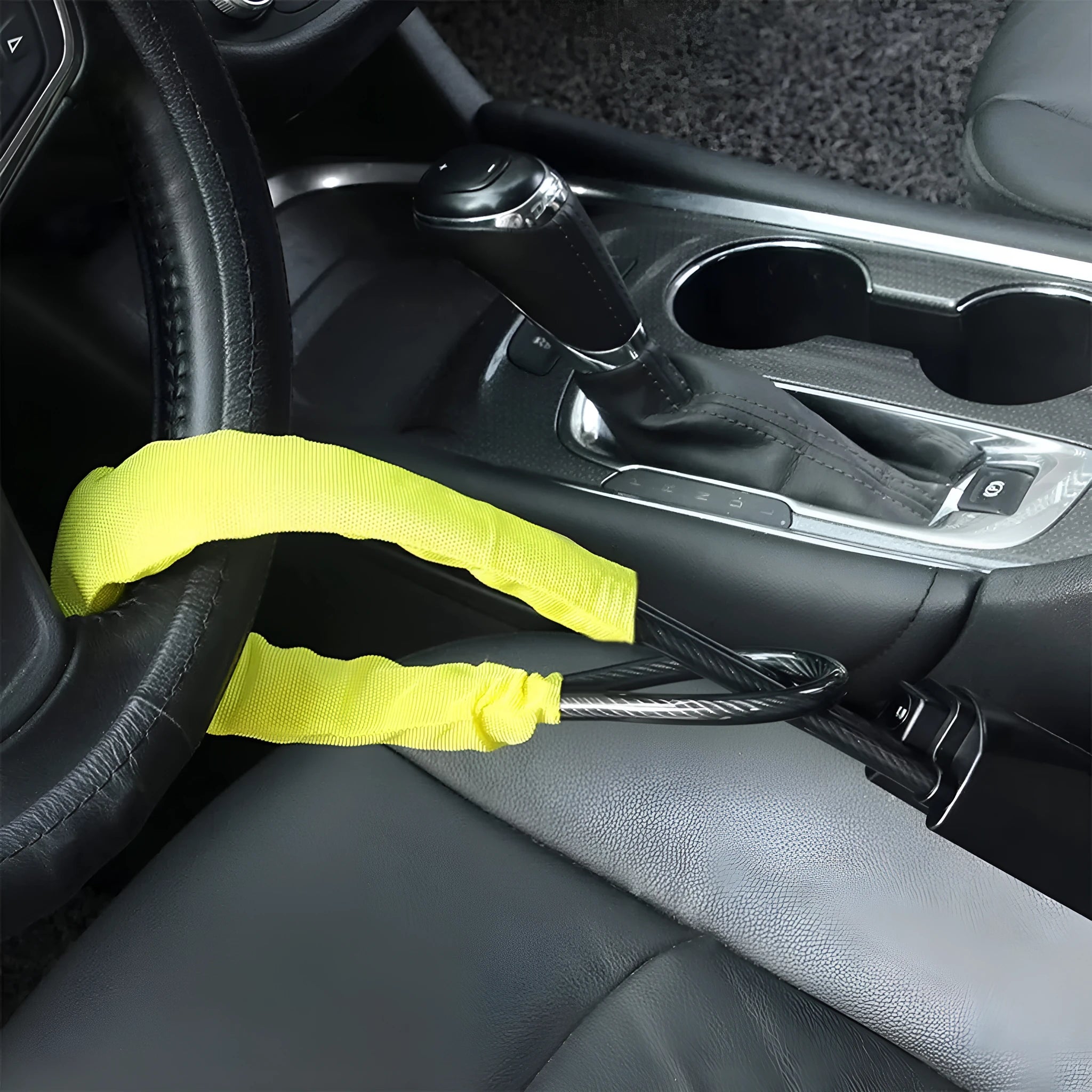 Red iron car steering wheel lock with wire rope for General Motors vehicles on a steering wheel.