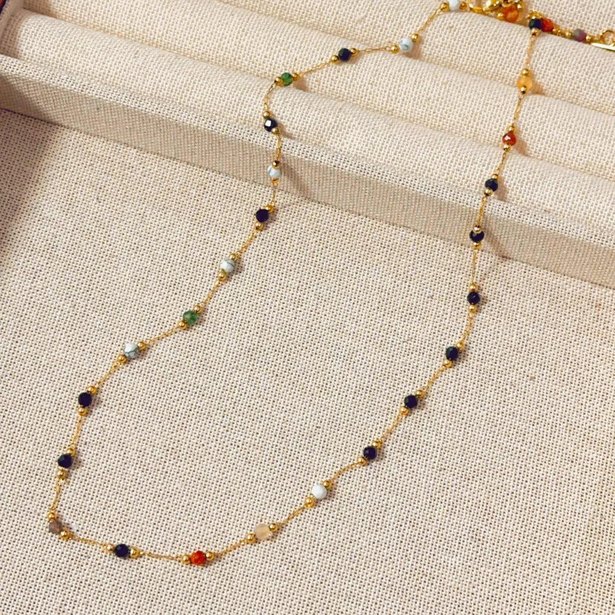 Gold coloured titanium steel necklace with an O-ring chain and a natural stone pendant.