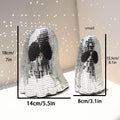 Silver glass Halloween ghost decoration with mosaic mirror patch design on a desktop.