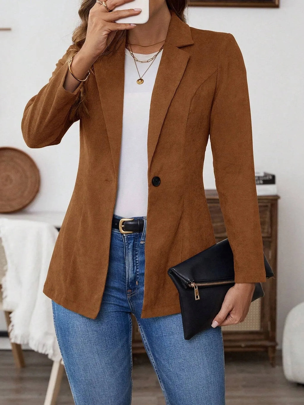 Brown single-breasted suit coat with lapel and long sleeves on a hanger.