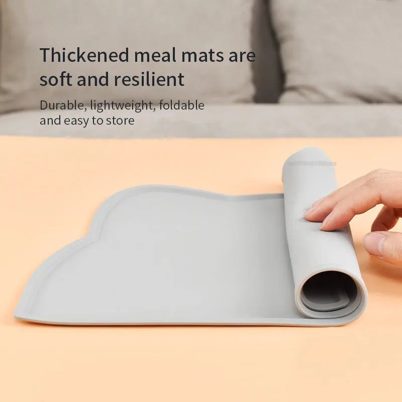 Blue silicone cat head-shaped pet feeding mat on a wooden floor
