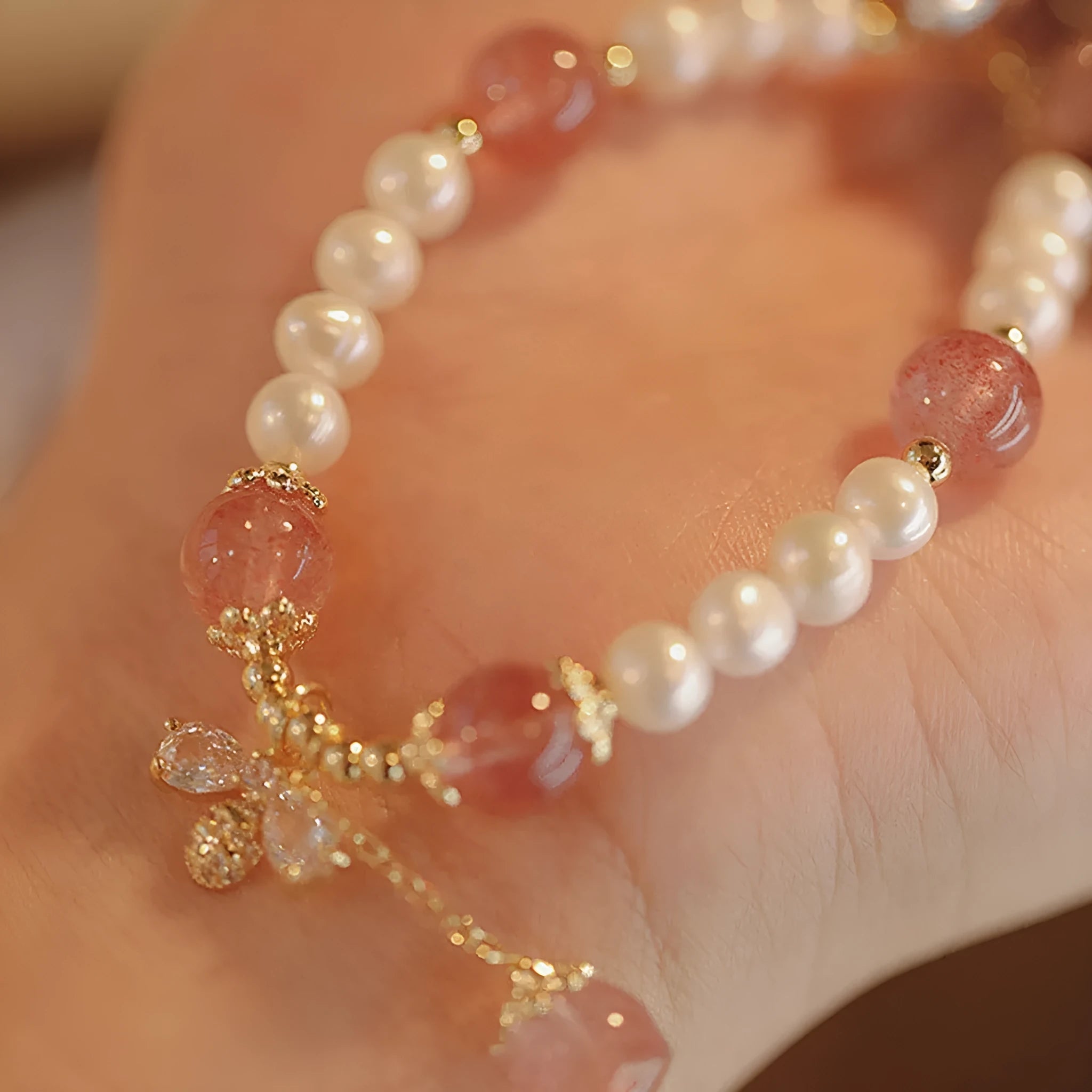 Strawberry quartz crystal bead bracelet for women with a central bow decoration.
