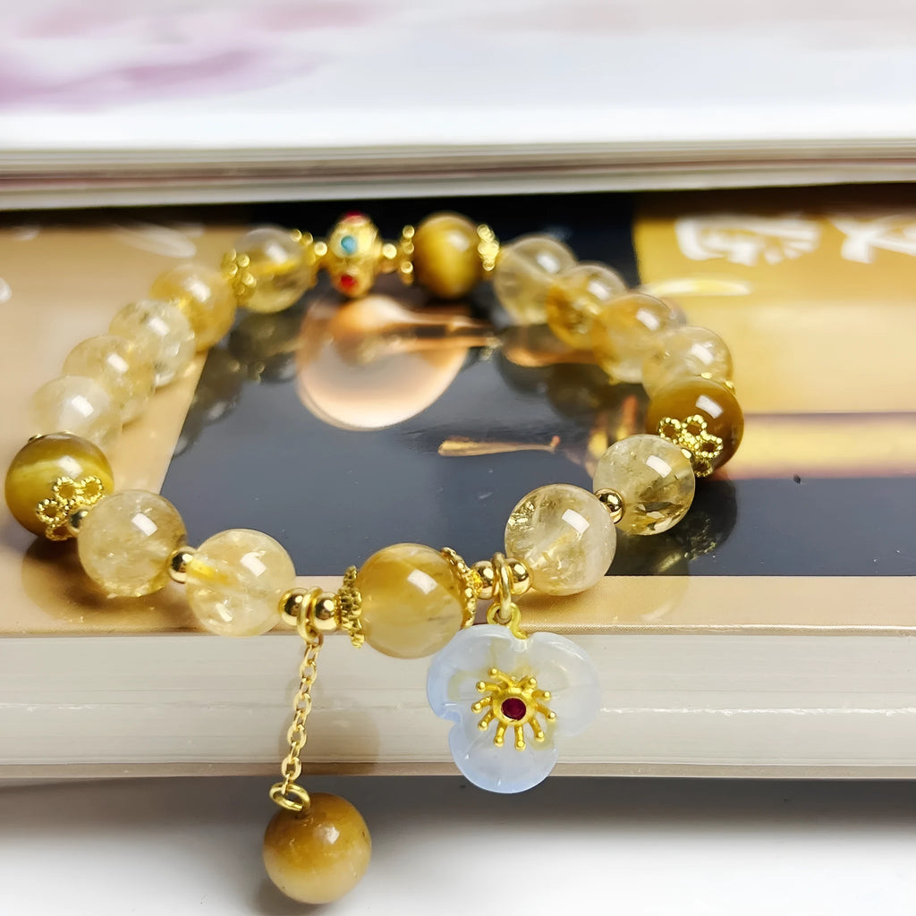 Close-up of a handcrafted citrine crystal bracelet for women with a floral tassel pendant.