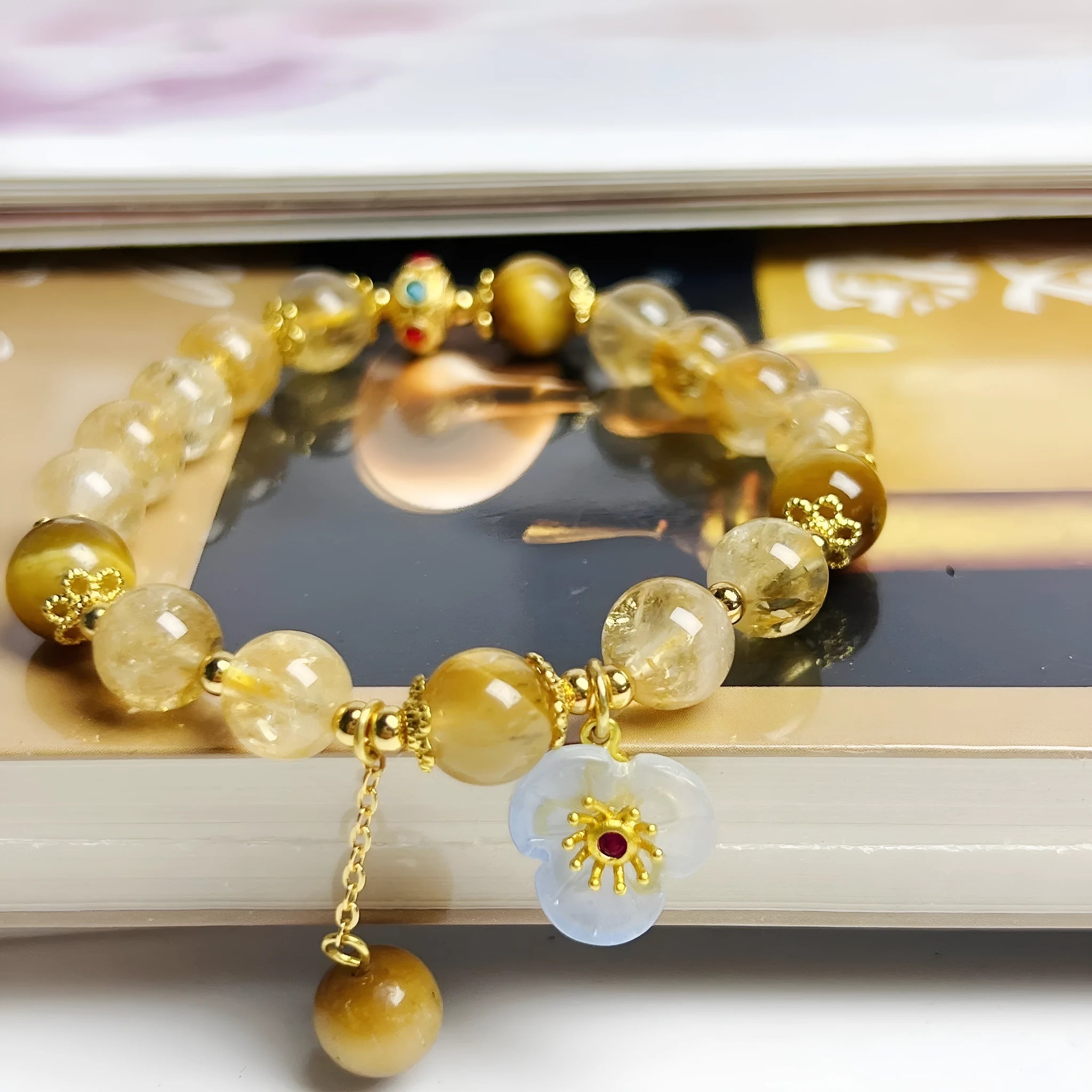 Close-up of a handcrafted citrine crystal bracelet for women with a floral tassel pendant.