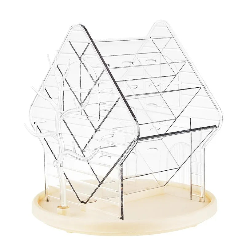 Rotating clear plastic cosmetics organiser box with multiple tiers on a wooden dresser.