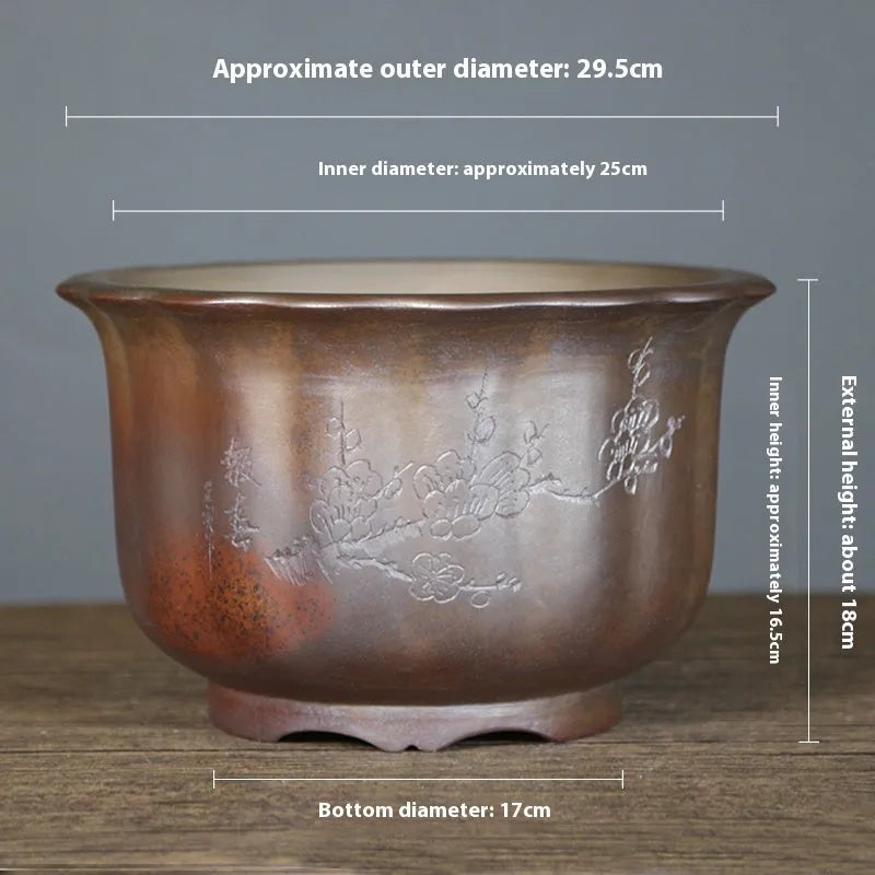 Antique carved ceramic flower pot with wood burning finish on a wooden table.