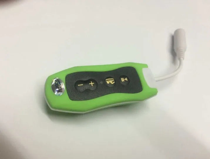 Compact black waterproof MP3 player earphone with USB cable, shown next to a ruler for scale.