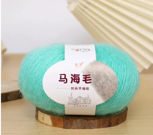 Ball of mohair yarn for DIY scarf knitting in one of 34 colours, including white, pink, blue, and green.